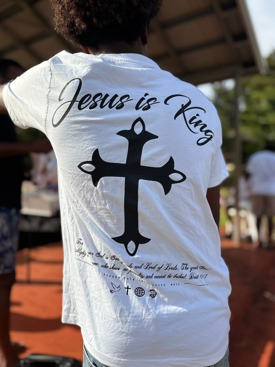 A participant wearing a white T-shirt with a cross and the words Jesus is King